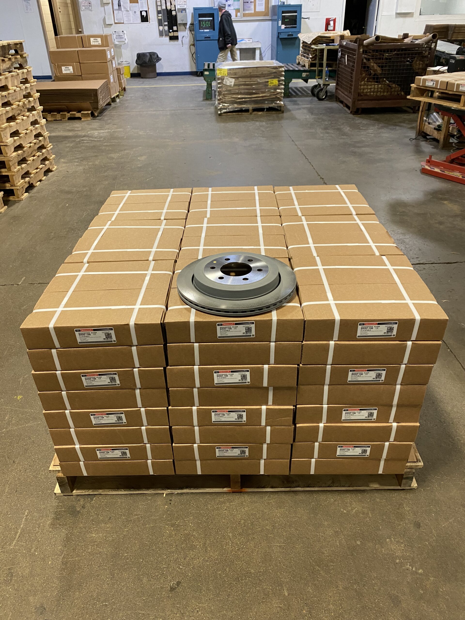 A brake rotor is placed on top of palleted boxes